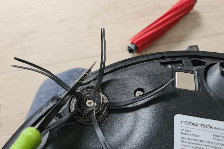 Волосы, намотанные на боковую щетку Roborock S7 MaxV Ultra, отрезают ножом